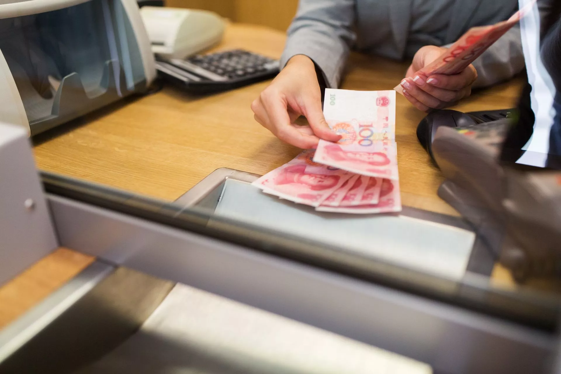 台中當鋪實體櫃檯現金點交畫面，工作人員於櫃檯前清點鈔票，象徵合法當鋪借款流程、資金周轉與費用透明的借款情境